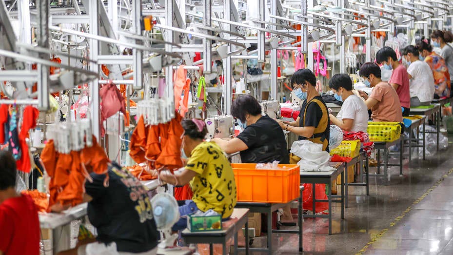 Workers labor in a factory of bathing suits in Jinjiang in southeast China's Fujian province Tuesday, Sept. 28, 2021.