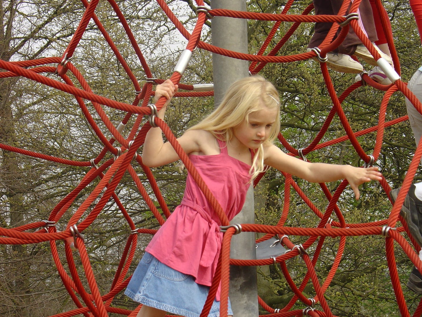 Little girl climbing rope structure
