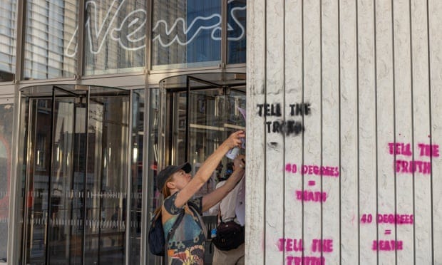 On the hottest day in UK history Extinction Rebellion protesters stencil slogans such as “tell the truth” and “40 degrees = death” on the walls of News UK.