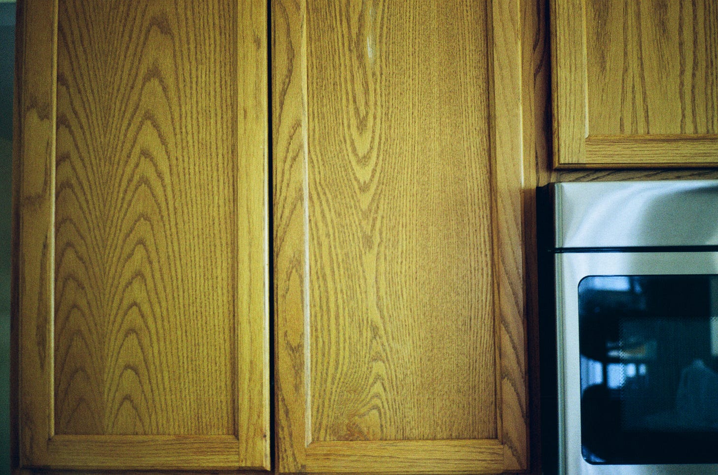 Wooden cabinet and the side of a microwave