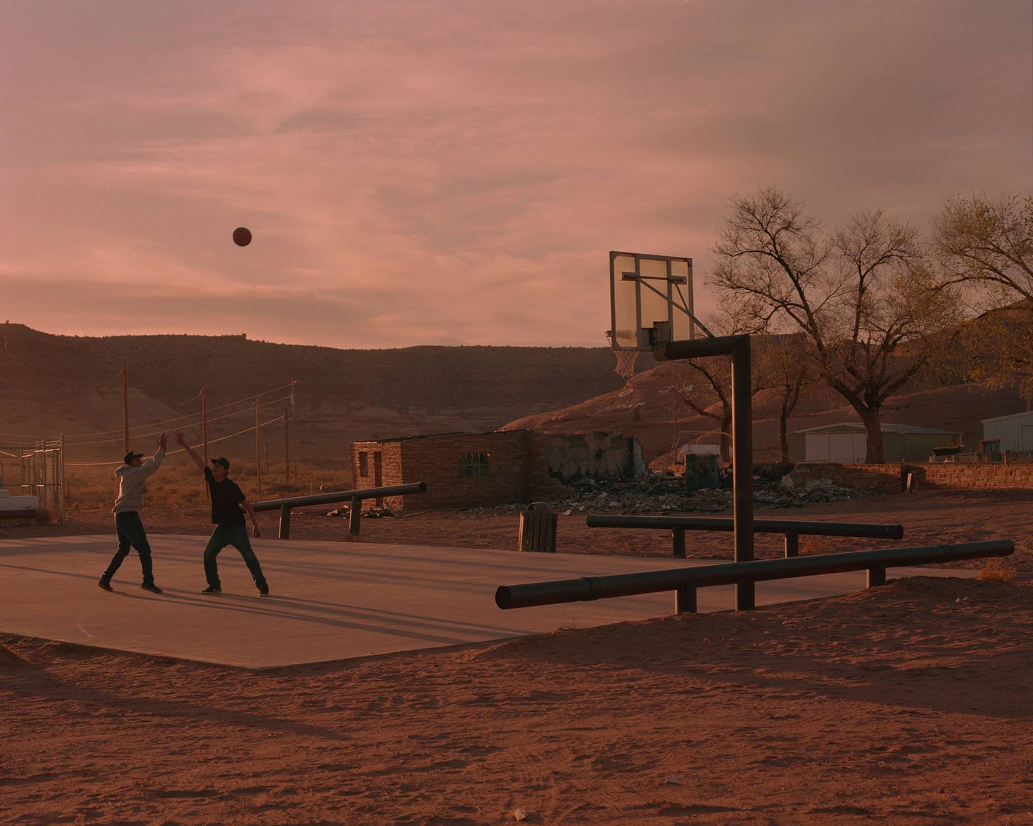 Teenage brothers Deion Salazar and Syrus Yazzieplay basketball in Oljato, Utah - a few miles from Monument Valley. Oljato was a major source for uranium mining in the 1940's and 50's causing serious health concerns for many of its residents.