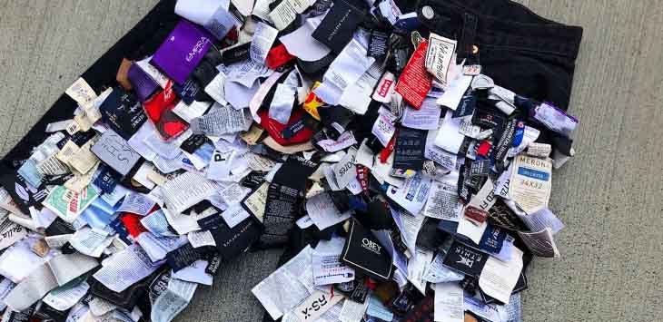 Photo of clothing labels sewn on to the front of a pair of black jeans