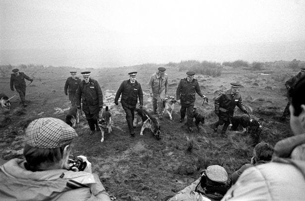 Police with sniffer dogs searching moors