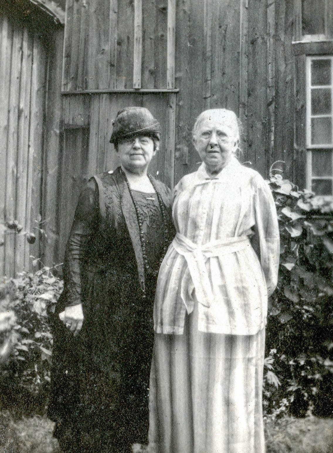 Two women standing near barn