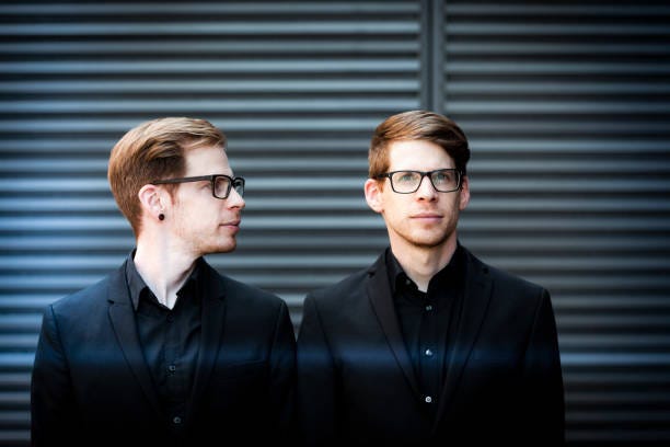 twin portrait twin brothers with black suits and glasses. 2 personalities stock pictures, royalty-free photos & images