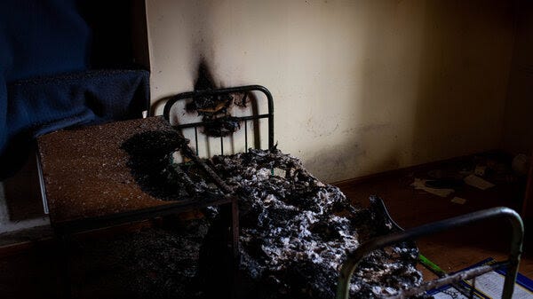 A burned cot in a dark room.