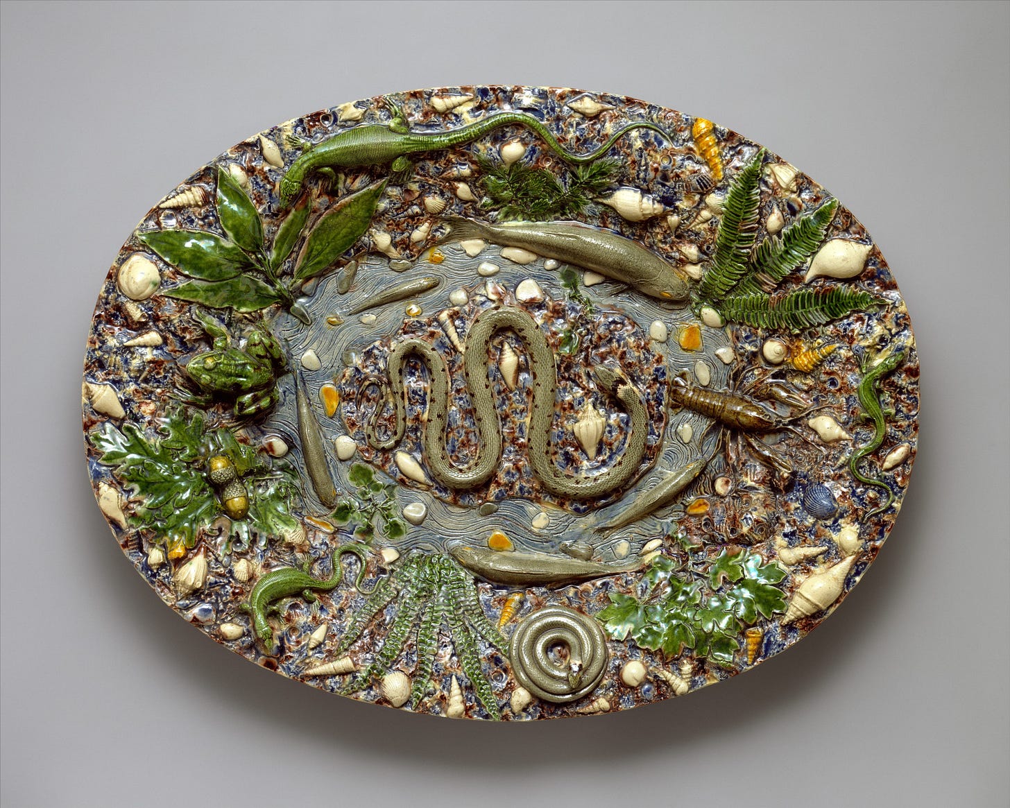 Ceramic platter with 3d natural elements like worms, plants and other bugs.