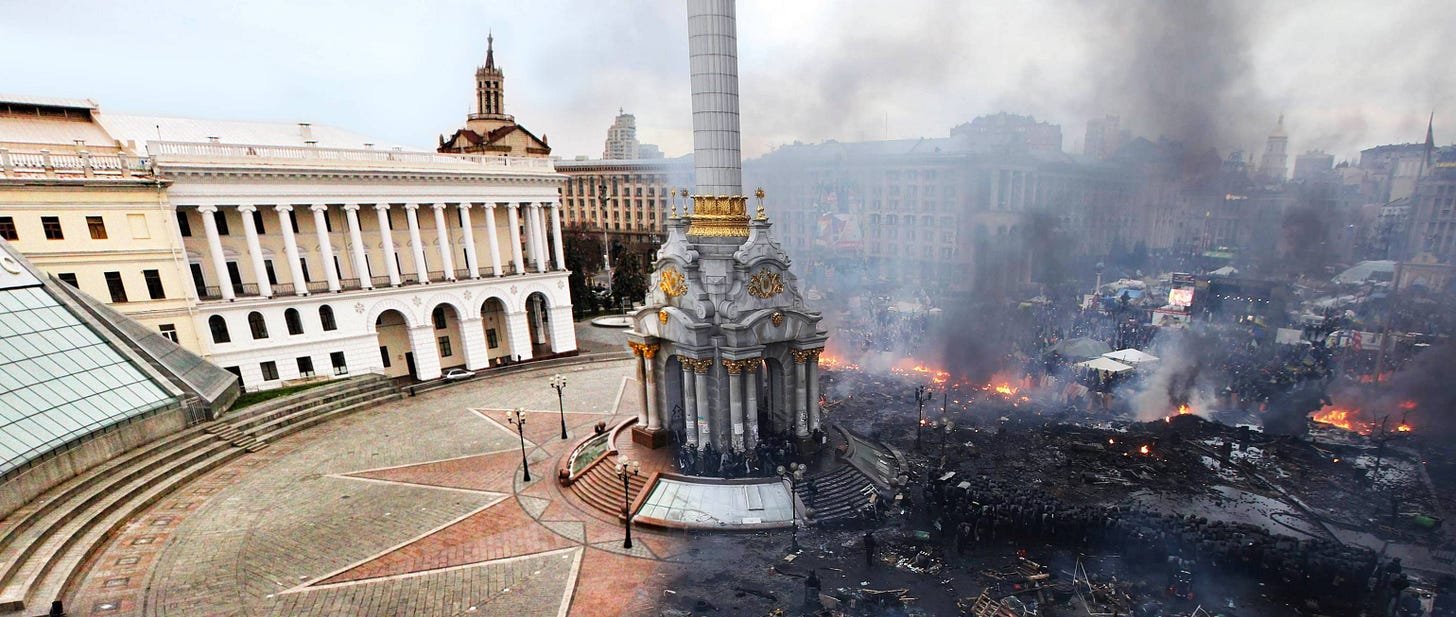 In the left-half of the image, Independence Sq in Ukraine emulates the idea of harmony and peace with classical architecture, and on the right the same square is in ruins, with active fires and people filling the street. In the left-half of the image, Independence Sq in Ukraine emulates the idea of harmony and peace with classical architecture, and on the right the same square is in ruins, with active fires and people filling the street.
