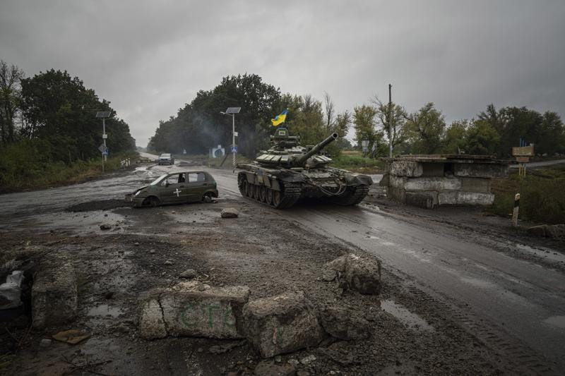 A Ukrainian tank drives past former Russian checkpoint in the recently retaken area of Izium, Ukraine, Friday, Sept. 16, 2022. (AP Photo/Evgeniy Maloletka)