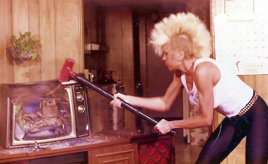 A 1980s image of singer Wendy O. Williams of the Plasmatics seen with a blond mohawk smashing a television with a sledgehammer