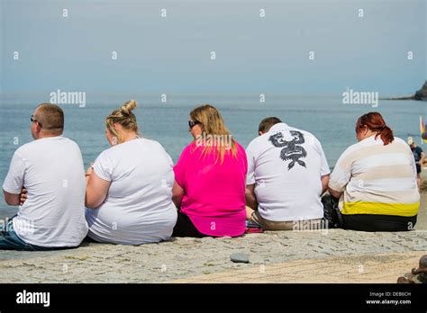 Rear view of a group of five overweight people men and ...