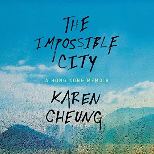 Cover of The Impossible City, a blue sky above mountains and a city skyline.