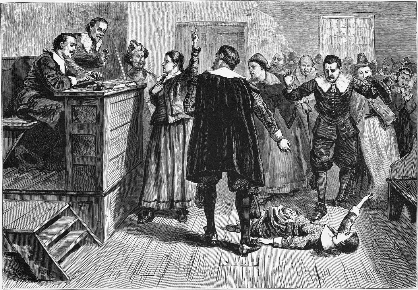 Salem witch trials: a girl lays on the ground as a courtroom full of people point and gesture.