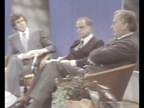 Screencap of Bill Boggs sitting with a miserable but civil pair: Roy Cohn and Gore Vidal