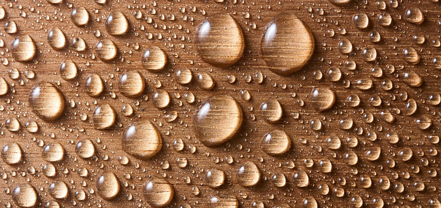 close up of water droplets on brown surface