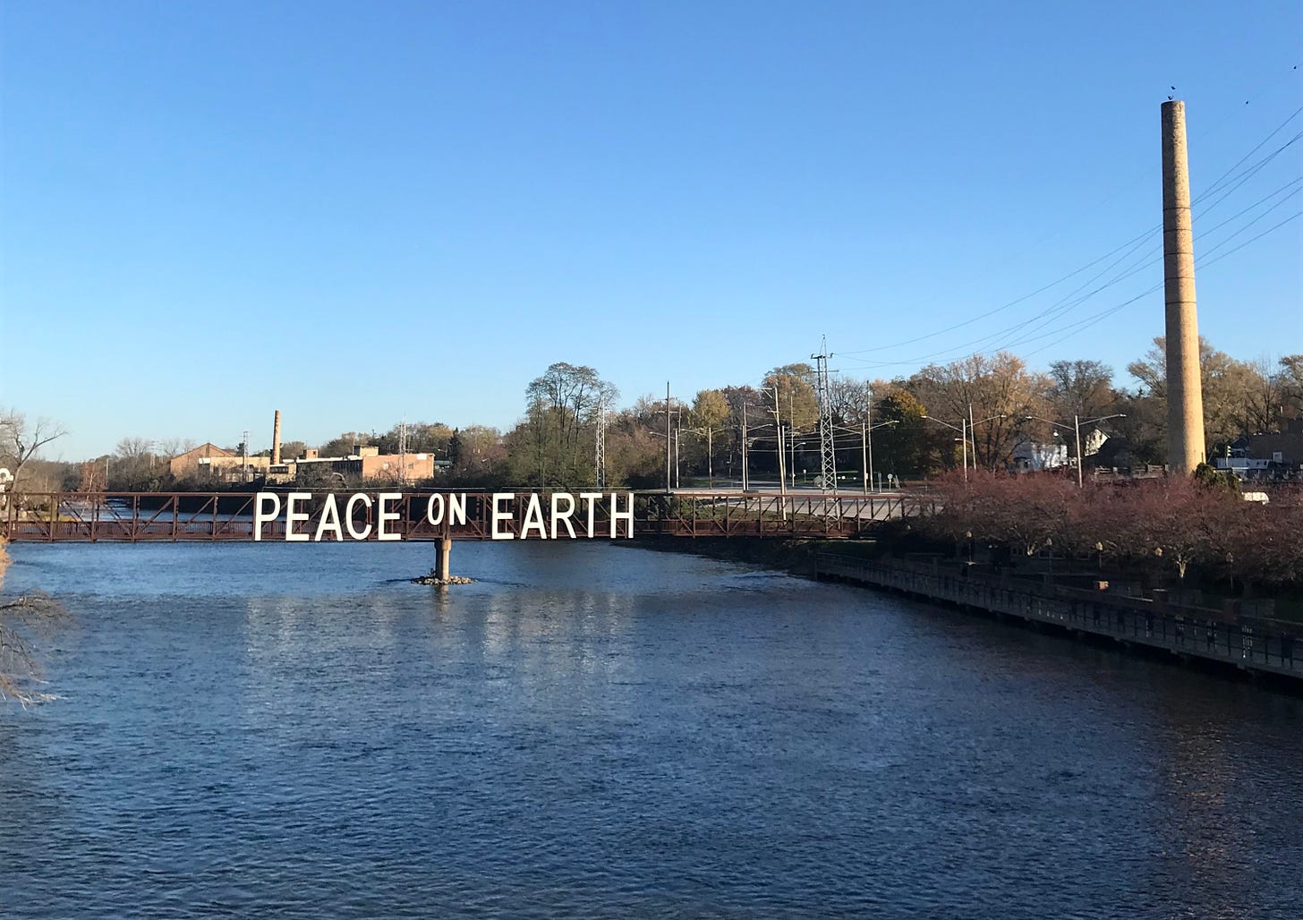 Batavia's Peace on Earth sign visible on a pedestrian bridge over the Fox River.
