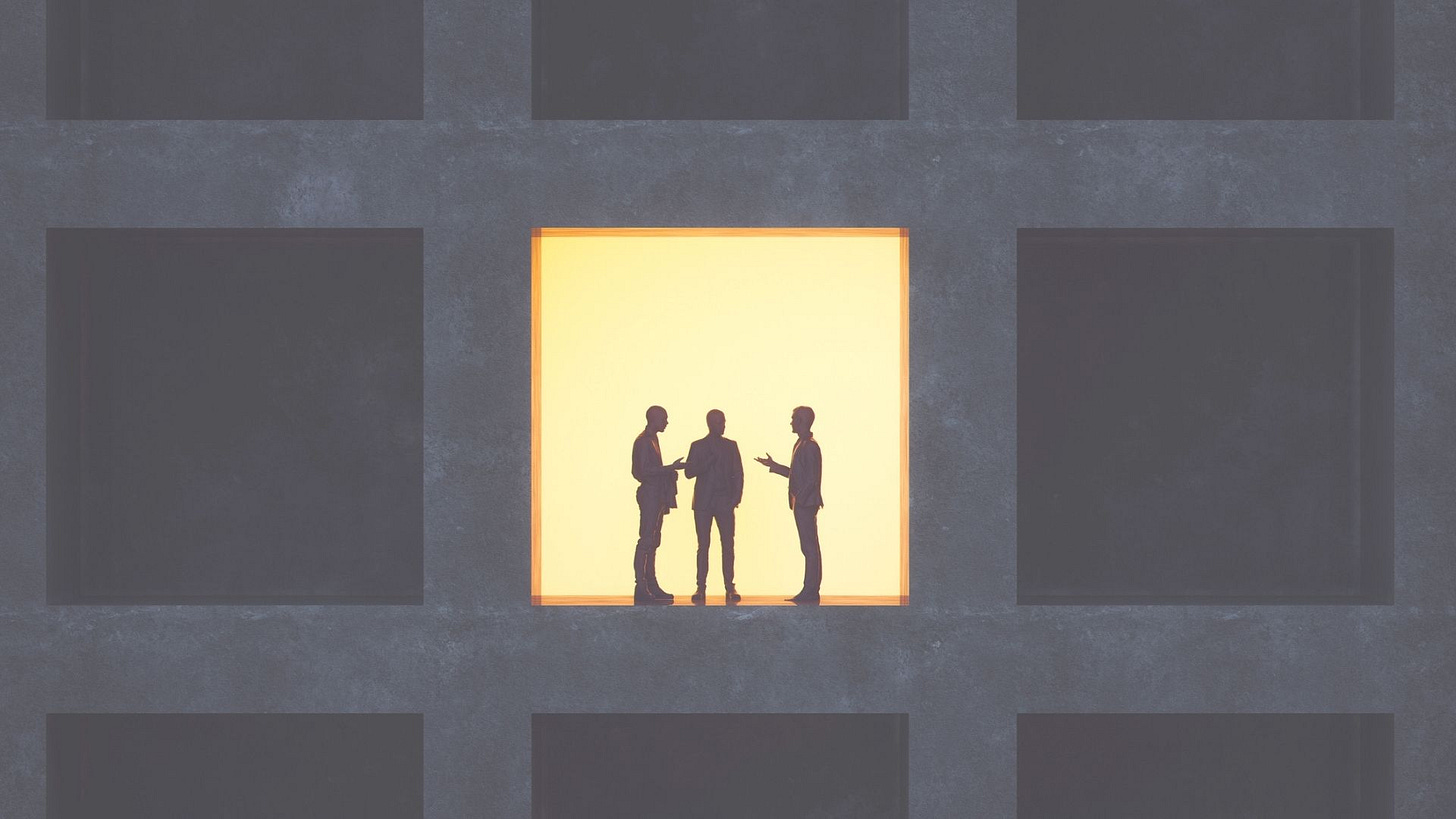 3 people talking inside a building