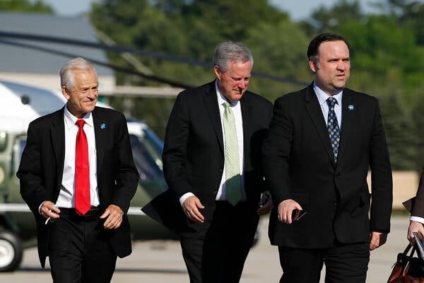 Peter Navarro, left, and Dan Scavino Jr., right, walk with Mark Meadows as they follow President Donald Trump aboard Air Force One in 2020.