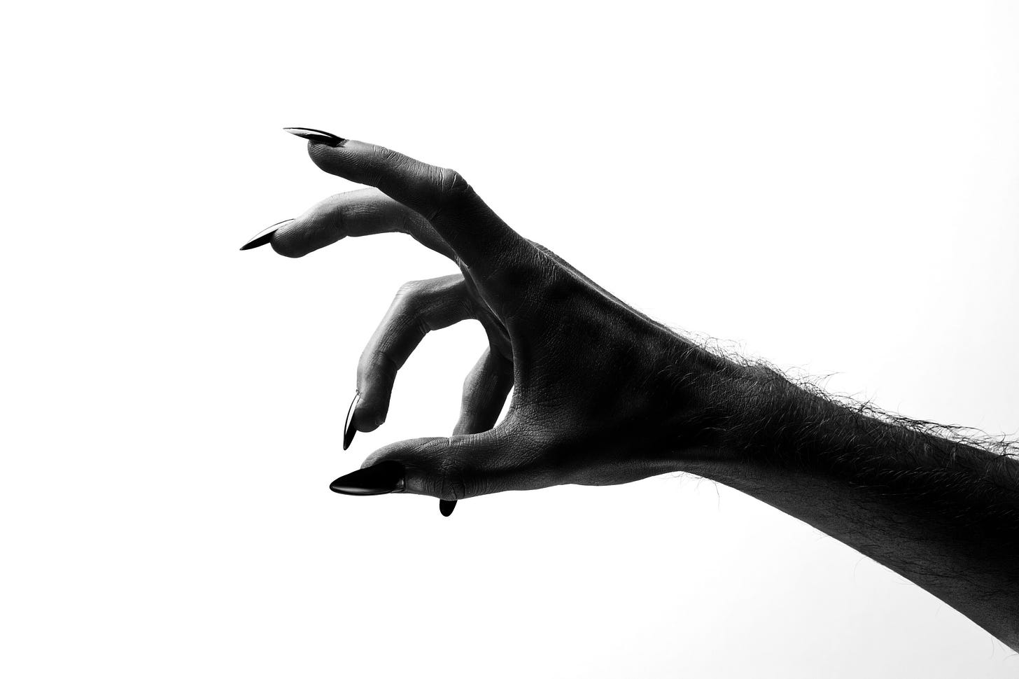 A dark clawed hand reaches sinisterly against a white background.