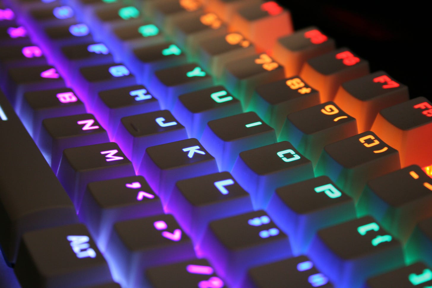 A computer keyboard lit up with rainbow lights
