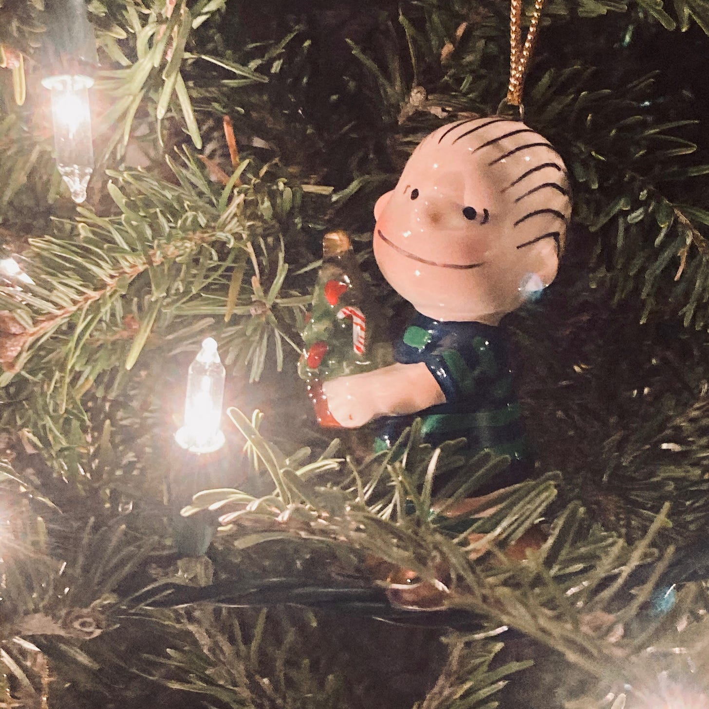 Ceramic ornament of Linus from Peanuts hanging in a Christmas tree