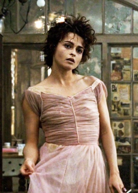 The dress is pink, and doesn't fit her well; it highlights her flat chest, and her dark hair is short and very messy.