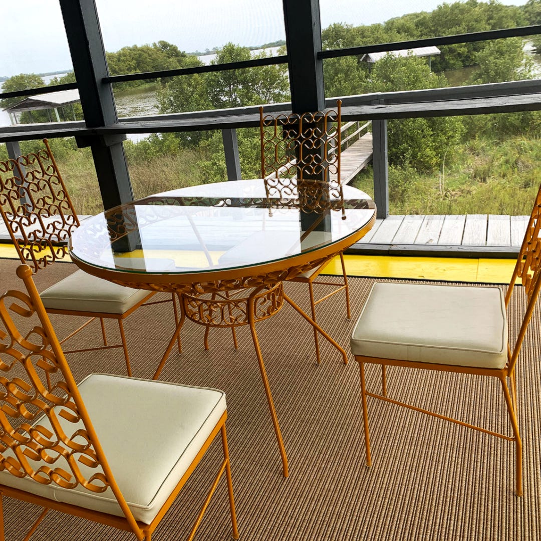 Cedar Key porch with midcentury modern dining set overlooking wetland and bayou