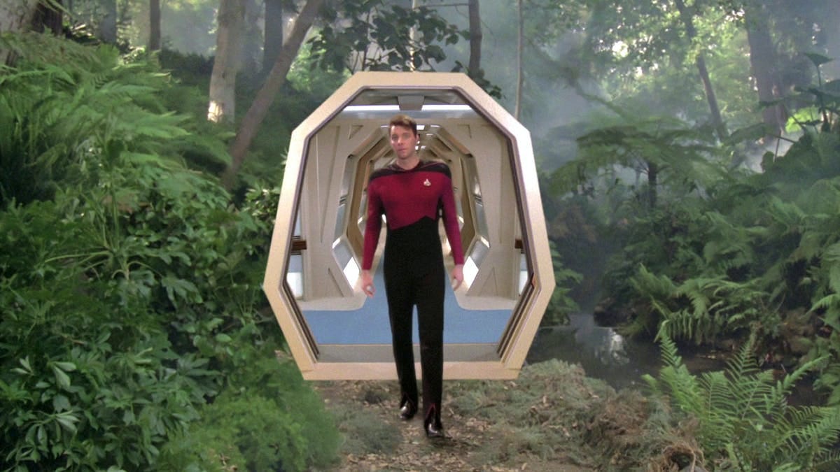 This image shows Commander William Riker (played by Jonathan Frakes) walking into the U.S.S. Enterprise-D's holodeck for the first time in Star Trek: The Next Generation's pilot episode ("Encounter at Farpoint"). Riker walks into a woodland (or jungle) setting, with the holodeck's open door and an Enterprise corridor visible behind him. This image shows Commander William Riker (played by Jonathan Frakes) walking into the U.S.S. Enterprise-D's holodeck for the first time in Star Trek: The Next Generation's pilot episode ("Encounter at Farpoint"). Riker walks into a woodland (or jungle) setting, with the holodeck's open door and an Enterprise corridor visible behind him.