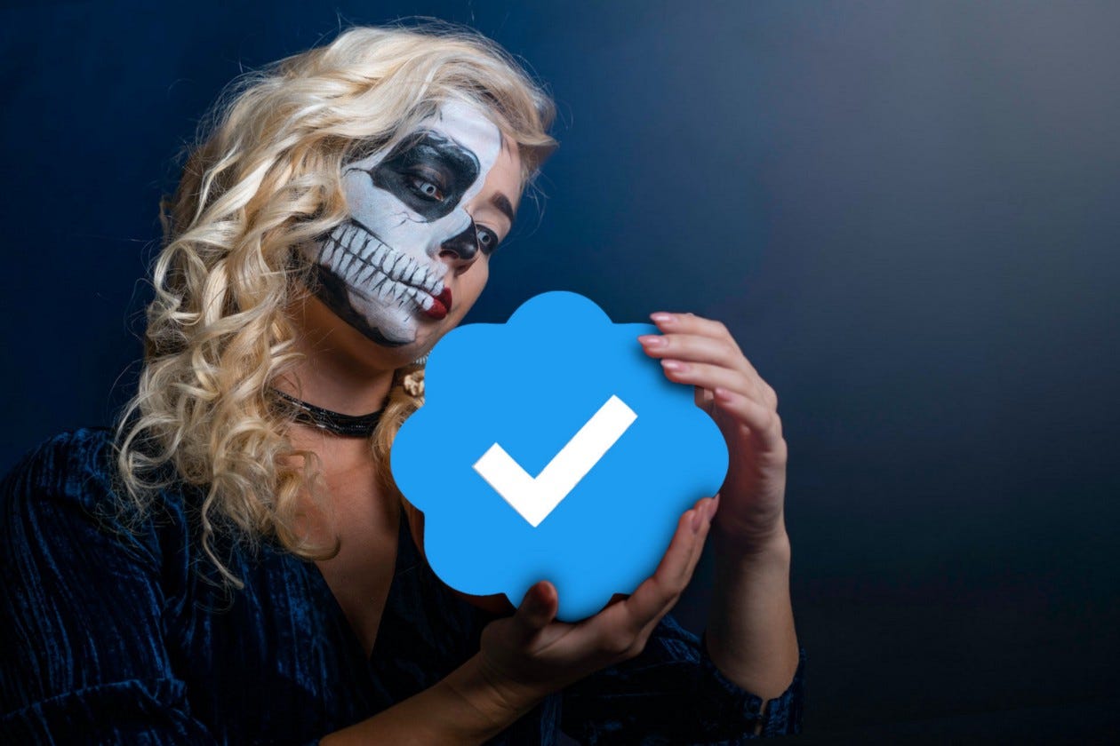 Woman in skeleton face paint holding Twitter verified icon.