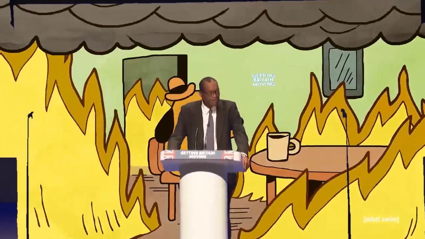 Kwasi Kwarteng, ex-Chancellor, giving a speech to Tory party conference, with a bluescreen behind showing an "everything's fine" cartoon scene, a room on fire.