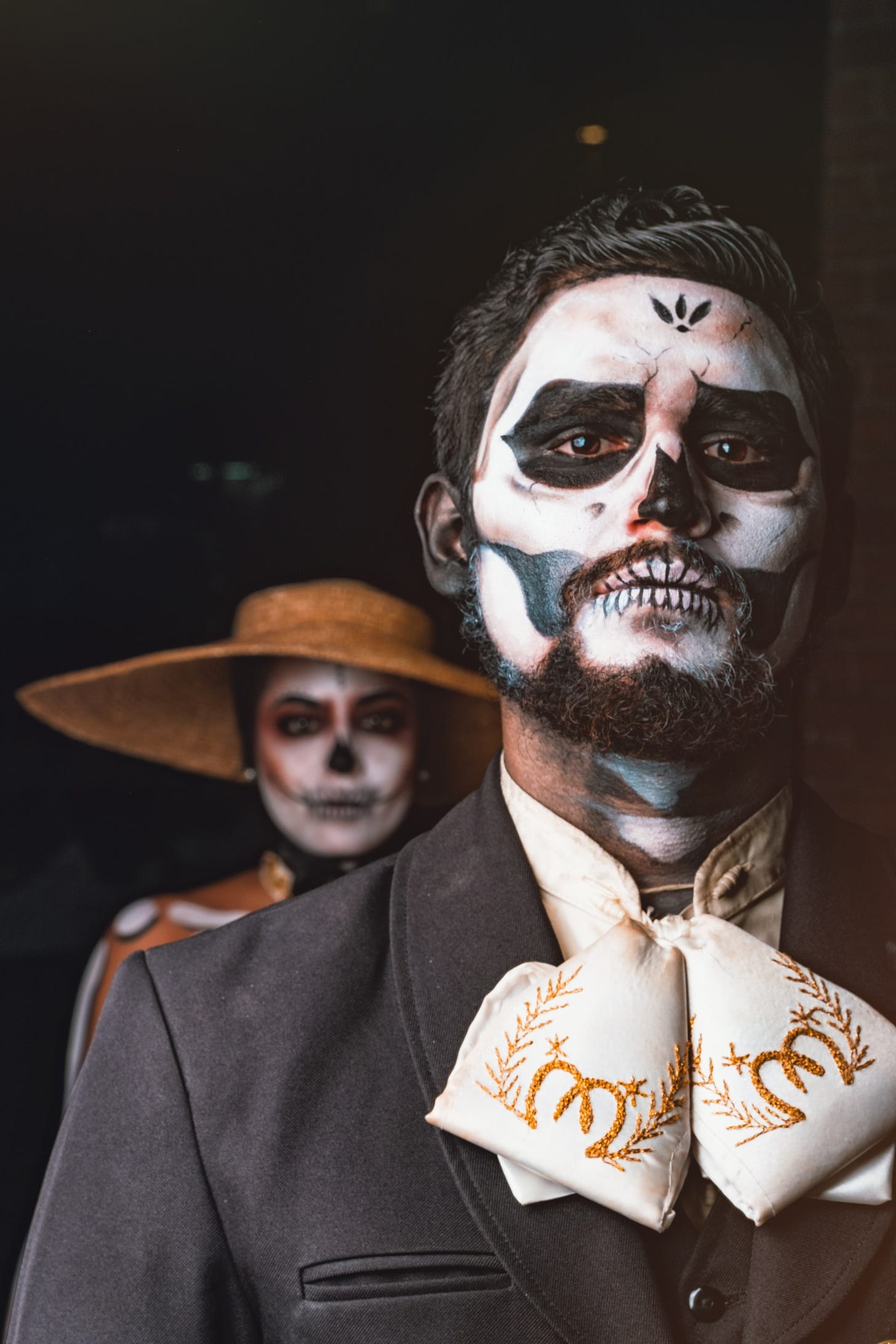 A man and a woman dressed in smart clothing with painted faces to look like skulls in celebration of the Day of the Dead, Mexico