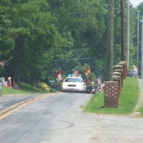 Leading off the parade is a police car and Boy Scout color guard.