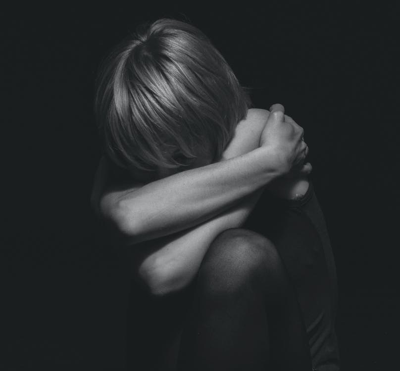 Free Grayscale Photo of a Person Hugging Self Stock Photo