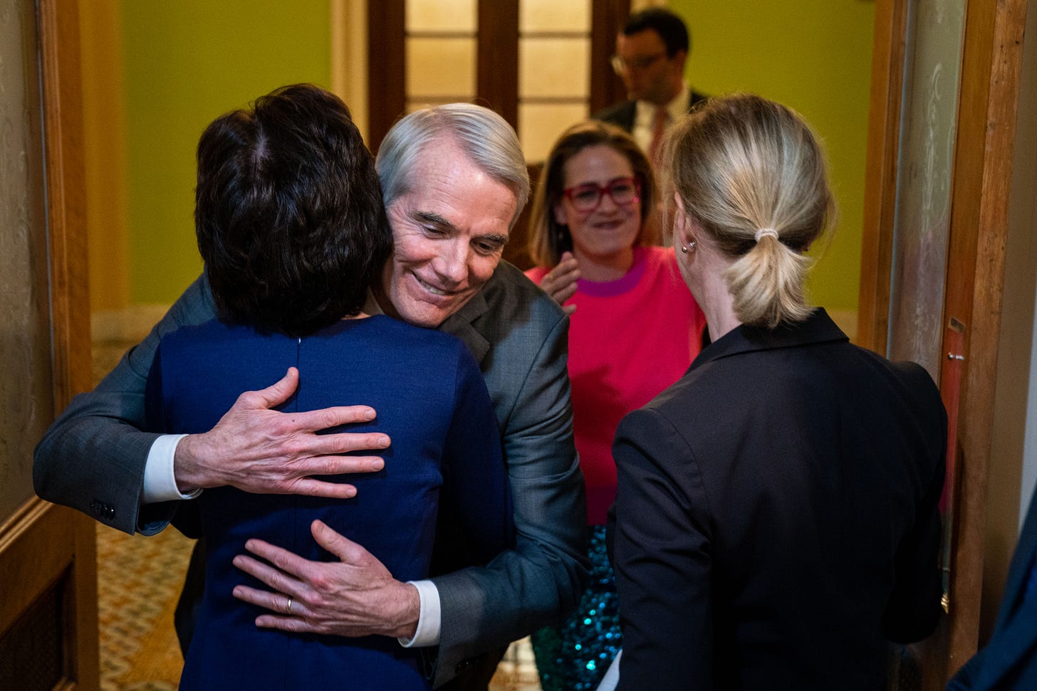 Sen. Rob Portman (R-OH) hugs Sen. Susan Collins (R-ME) as Sen. Kyrsten Sinema (D-AZ) moves to hug Sen. Tammy Baldwin (D-WI) following a news conference on the passage of the bipartisan Respect For Marriage Act through the Senate following a vote on Capitol Hill on Tuesday, Nov. 29, 2022 in Washington, DC. (Kent Nishimura / Los Angeles Times via Getty Images)