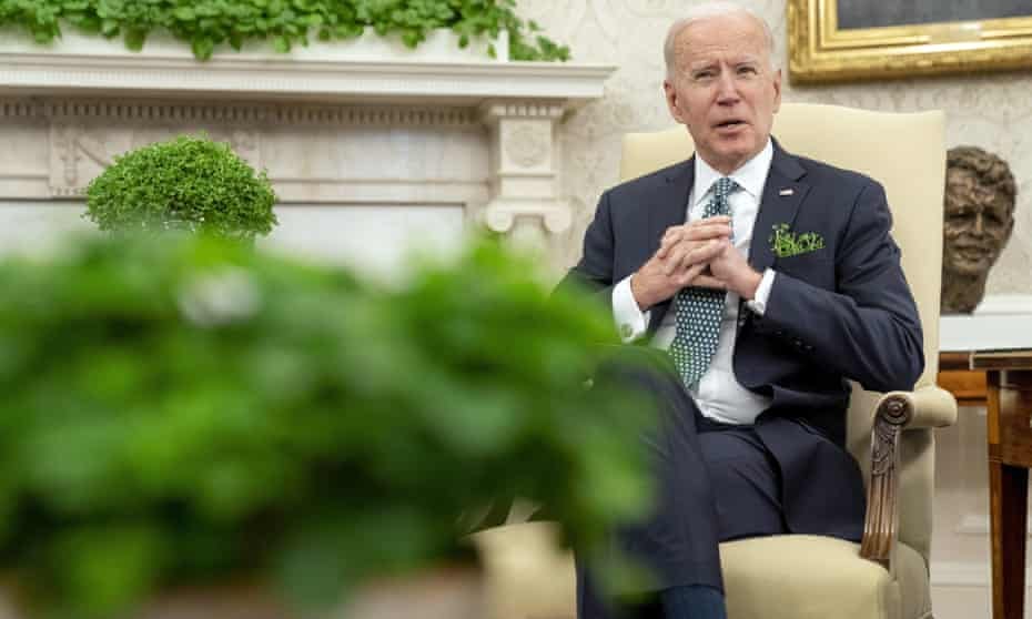 Joe Biden speaks in the Oval Office on St Patrick’s Day, in front of a bust of Robert F Kennedy.