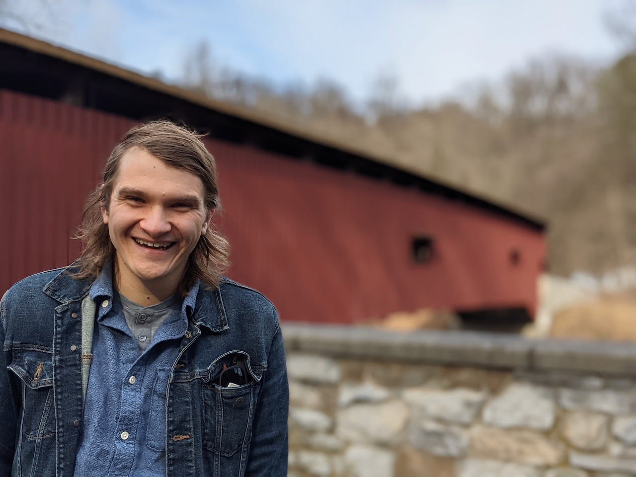 brett standing in front of a covered bridge