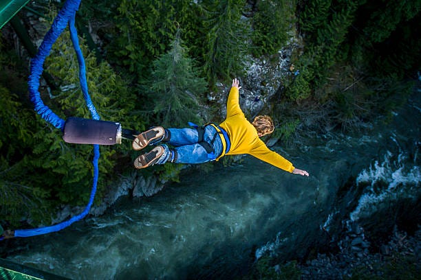 Bungee jumping. Young man bungee jumping over river. Bravery stock pictures, royalty-free photos & images