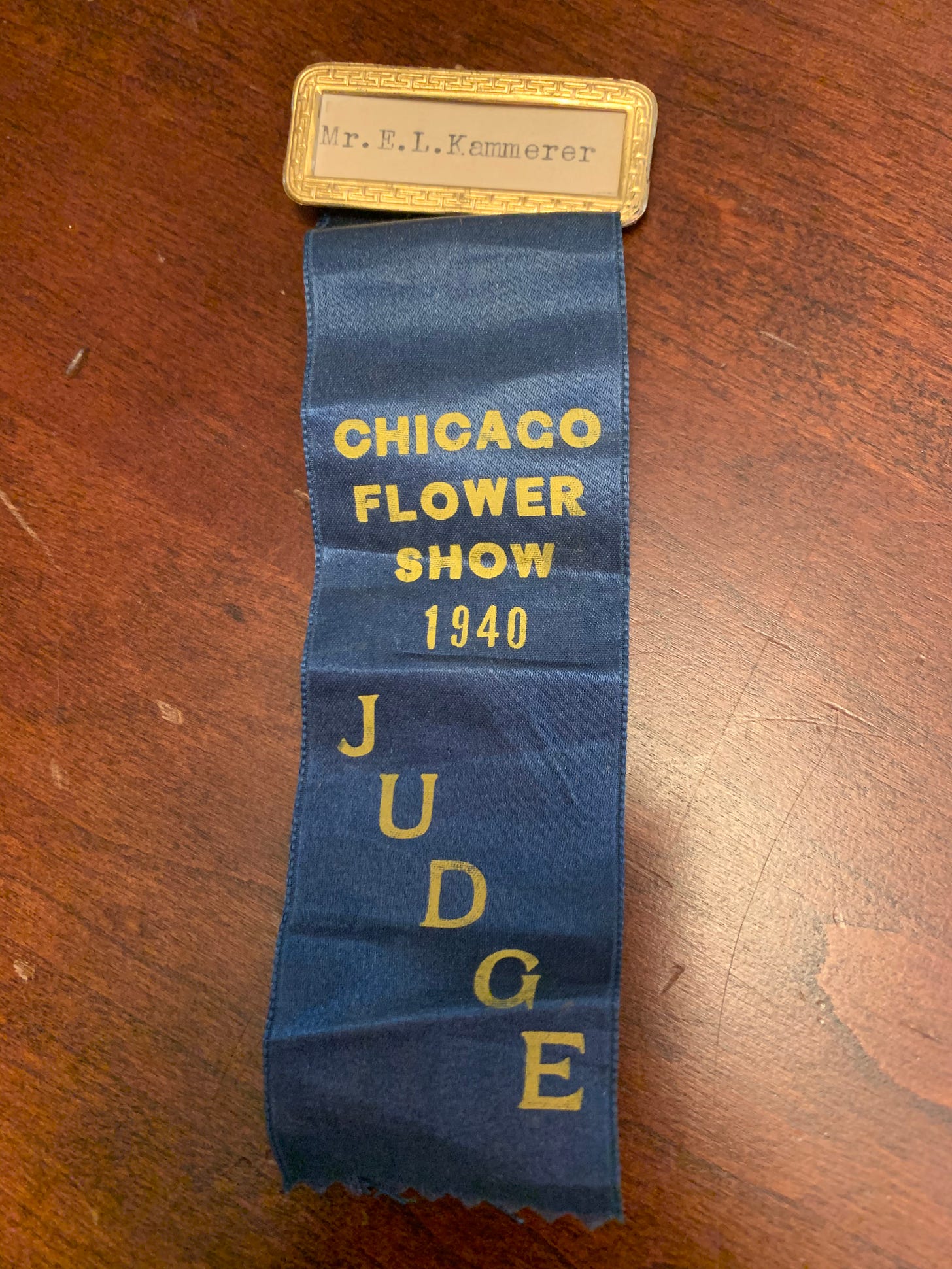 Photo of a Judge ribbon from the 1940 Chicago Flower and Garden Show. at the top a name plate reads: Mr. E. L. Kammerer