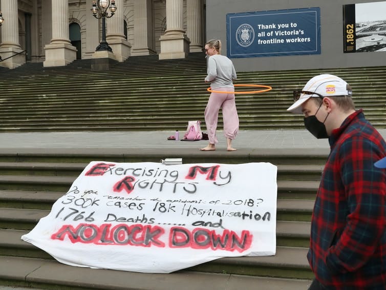 Woman protested with hula hoop and 'no lockdown' banner.