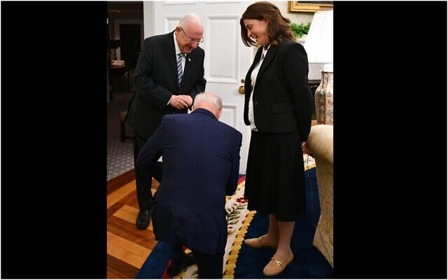 US President Joe Biden kneels before Rivka Ravitz, Israeli President Reuven Rivlin's chief of staff, after learning she has 12 children (Haim Zach/GPO)