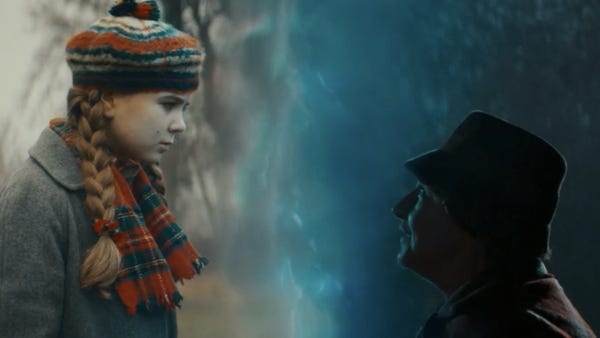 This image shows Peggy (played by Poppy Polivnick) facing Mrs. Hayward (played by Penelope McGhie)--her older self--across a split in spacetime that divides the image straight down the middle. This image shows Peggy (played by Poppy Polivnick) facing Mrs. Hayward (played by Penelope McGhie)--her older self--across a split in spacetime that divides the image straight down the middle.