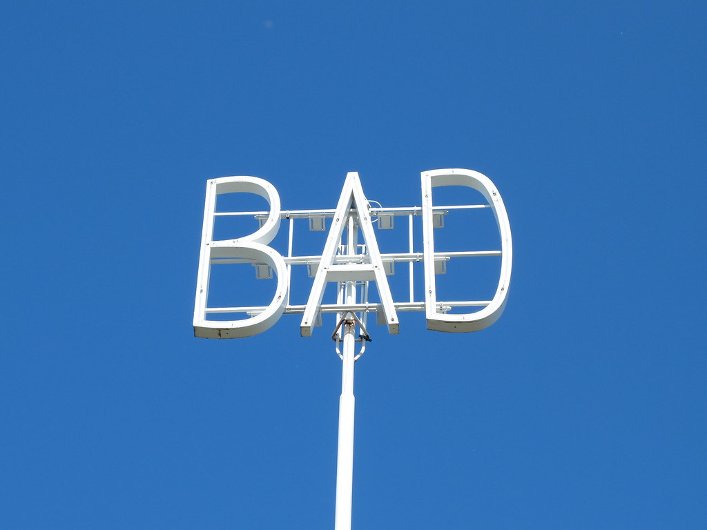 A white sign spelling BAD against a blue sky. "BAD" by gustav.ekenberg is licensed under CC BY-NC-SA 2.0 