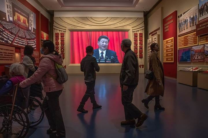 A group of people standing in a room with posters on the wall

Description automatically generated with medium confidence