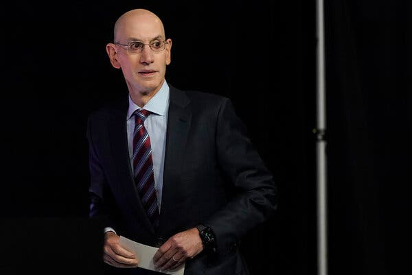 N.B.A. Commissioner Adam Silver in a dark-colored suit and a striped tie.