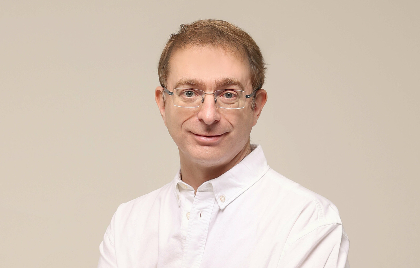 Quarter-length portrait of Tailscale CEO Avery Pennarun, who is wearing a white button-down shirt and rimless, rectangular glasses