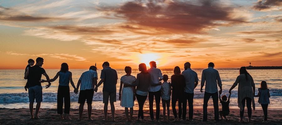 Friends and family watching sunset on the beach