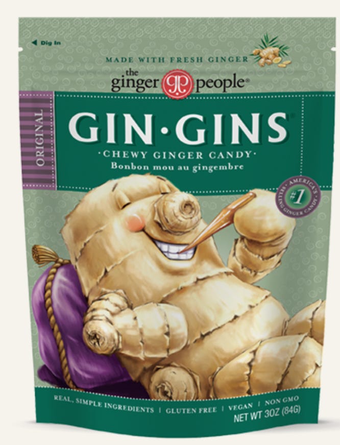 a package of gin gin chewy ginger candy. it is a green bag featuring a cartoon ginger root eating a ginger chew.