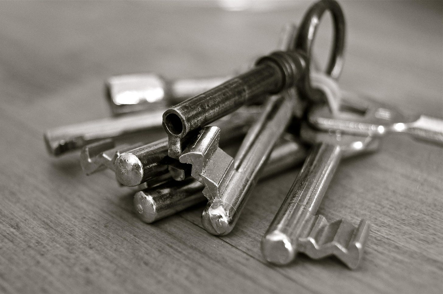 A close up image of several metal keys. One is darker than the rest. 
