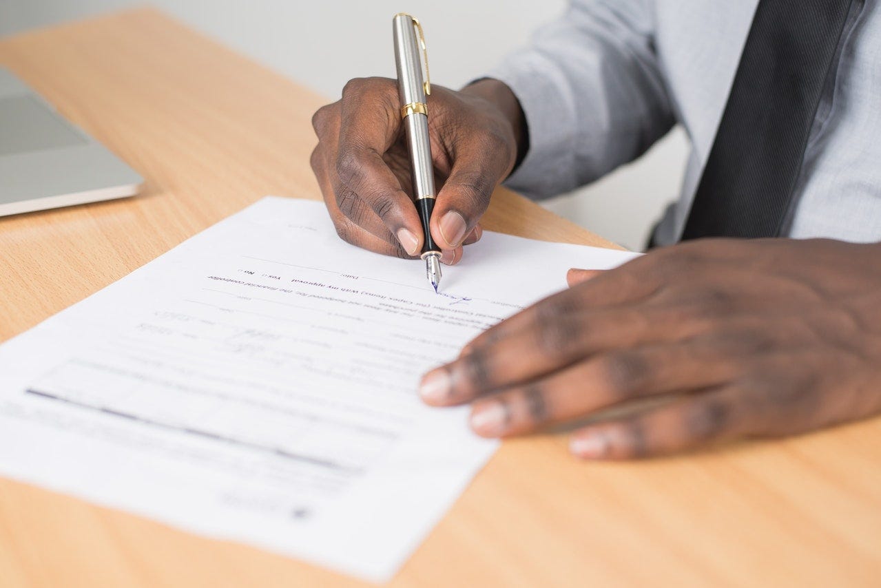 male hand signing a document