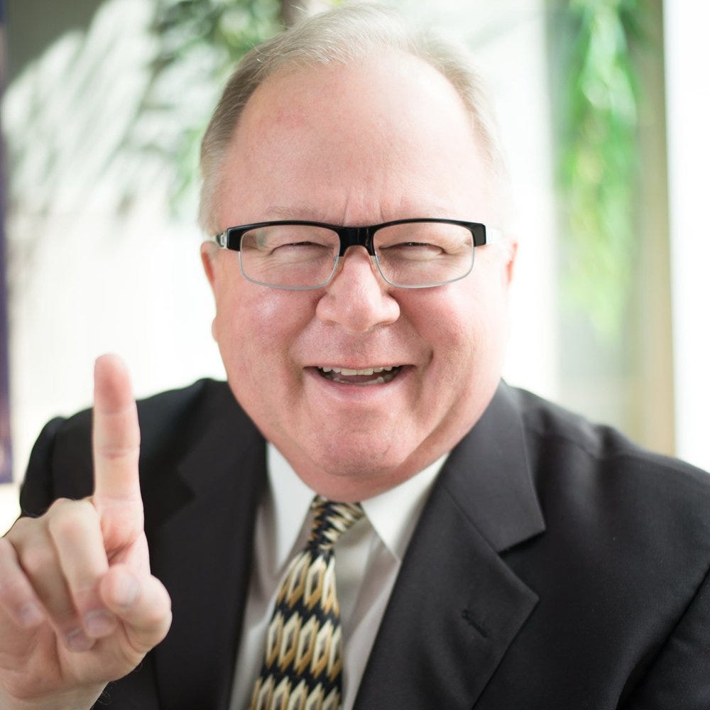 a man wearing glasses and a suit